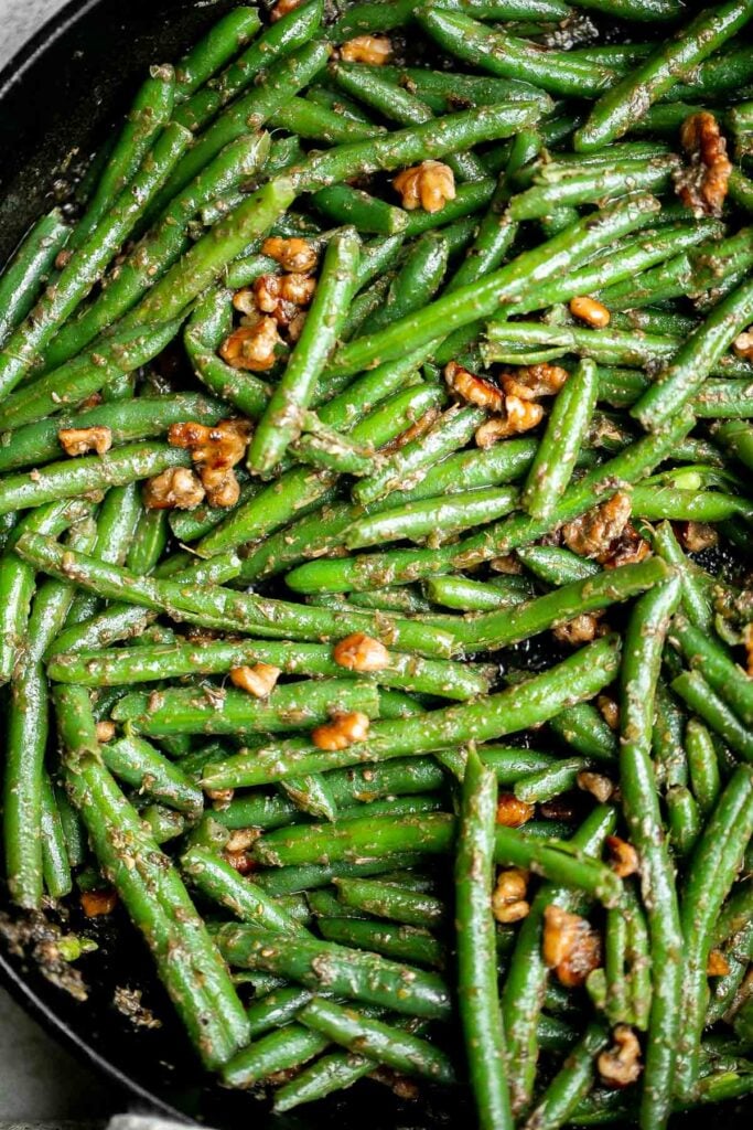 Pesto green beans is a simple side dish that is quick and easy to make in under 10 minutes, tossed in buttery toasted walnuts and pesto. So delicious. | aheadofthyme.com