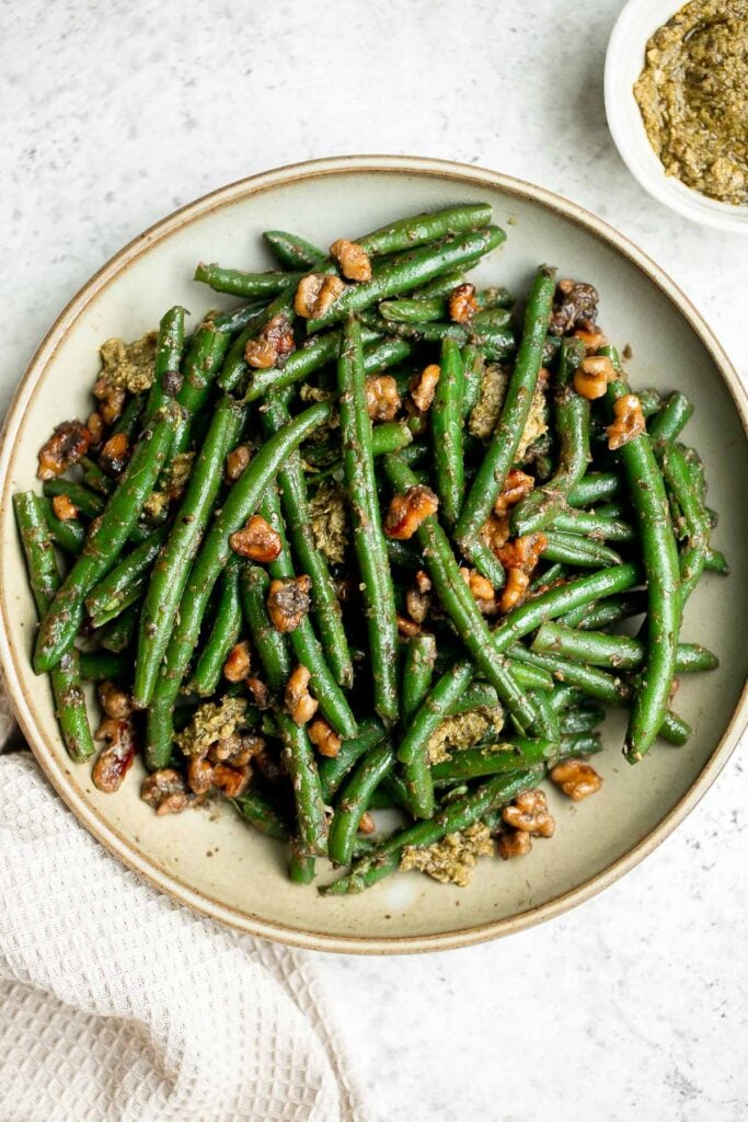 Pesto green beans is a simple side dish that is quick and easy to make in under 10 minutes, tossed in buttery toasted walnuts and pesto. So delicious. | aheadofthyme.com