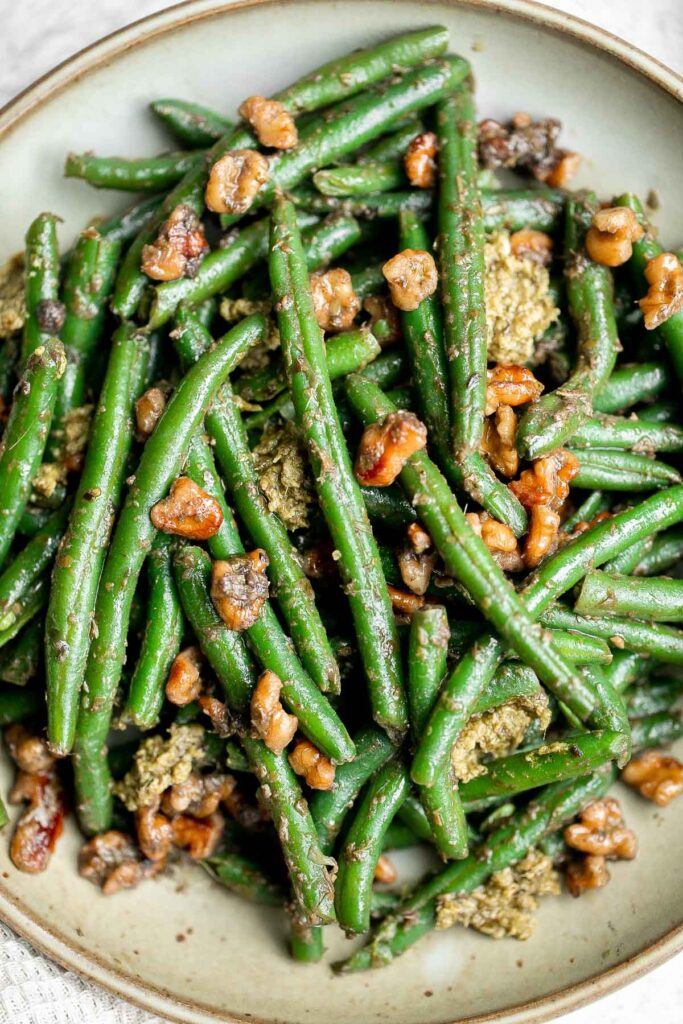 Pesto green beans is a simple side dish that is quick and easy to make in under 10 minutes, tossed in buttery toasted walnuts and pesto. So delicious. | aheadofthyme.com