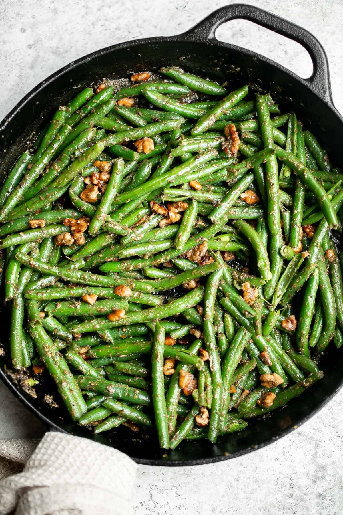 Pesto green beans is a simple side dish that is quick and easy to make in under 10 minutes, tossed in buttery toasted walnuts and pesto. So delicious. | aheadofthyme.com