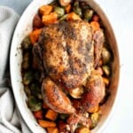 Pesto whole chicken baked over a bed of vegetables is the juiciest and most flavorful chicken you’ll ever taste. Quick and easy to prep and pop in the oven. | aheadofthyme.com