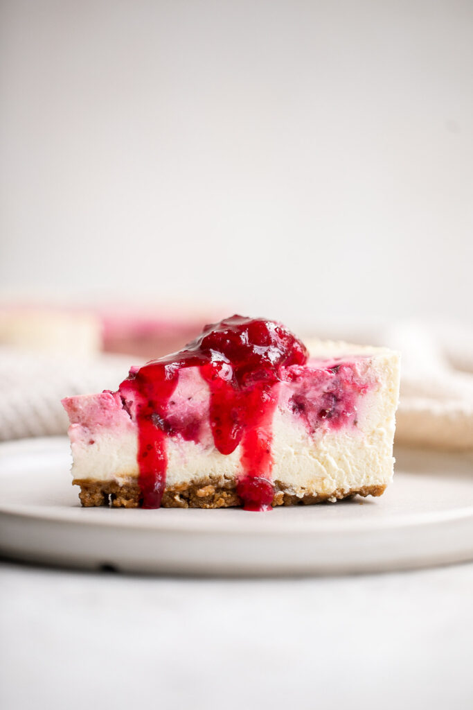 Cranberry sauce swirl cheesecake is creamy, smooth, and indulgent. With a gorgeous red swirl on top, it's the perfect holiday dessert for your next party. | aheadofthyme.com