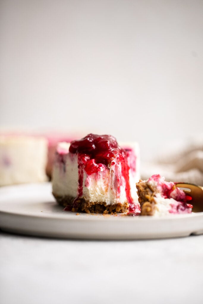 Cranberry sauce swirl cheesecake is creamy, smooth, and indulgent. With a gorgeous red swirl on top, it's the perfect holiday dessert for your next party. | aheadofthyme.com