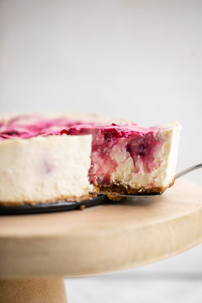 Cranberry sauce swirl cheesecake is creamy, smooth, and indulgent. With a gorgeous red swirl on top, it's the perfect holiday dessert for your next party. | aheadofthyme.com