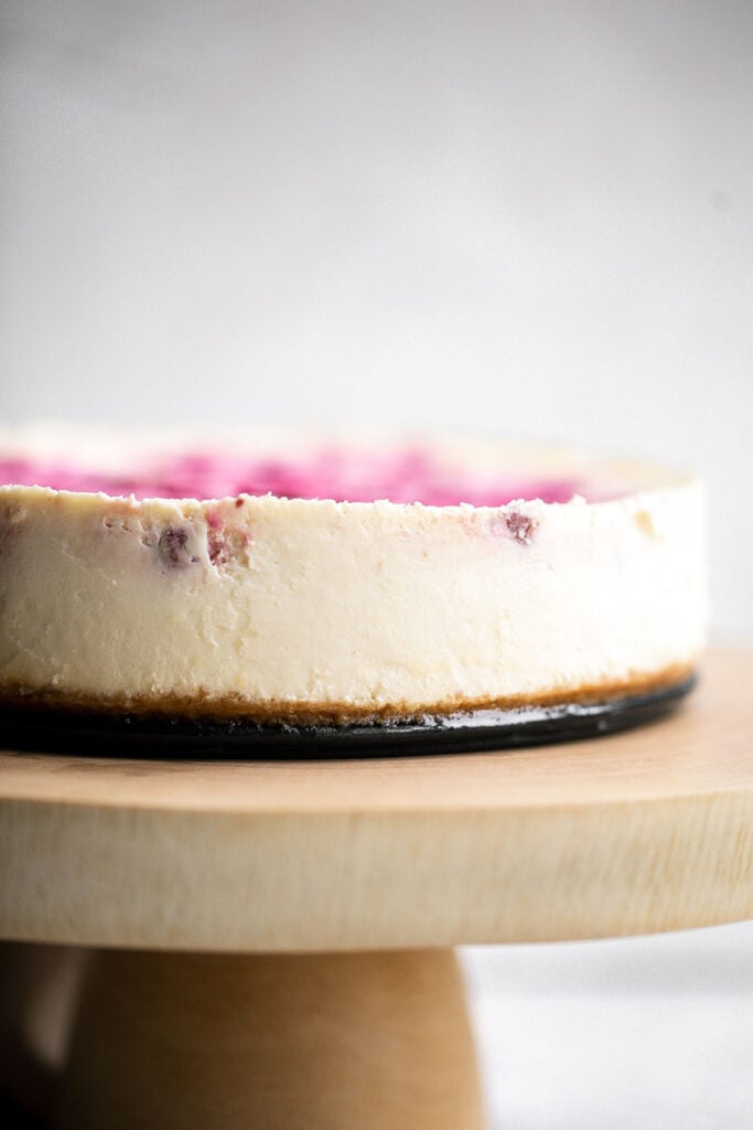 Cranberry sauce swirl cheesecake is creamy, smooth, and indulgent. With a gorgeous red swirl on top, it's the perfect holiday dessert for your next party. | aheadofthyme.com