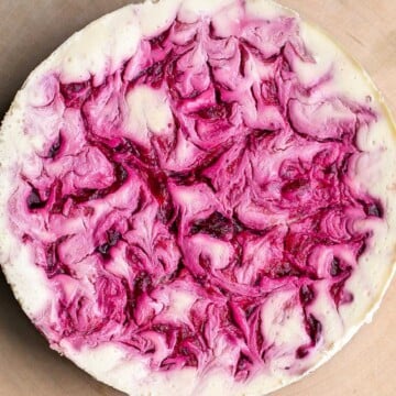 Cranberry sauce swirl cheesecake is creamy, smooth, and indulgent. With a gorgeous red swirl on top, it's the perfect holiday dessert for your next party. | aheadofthyme.com