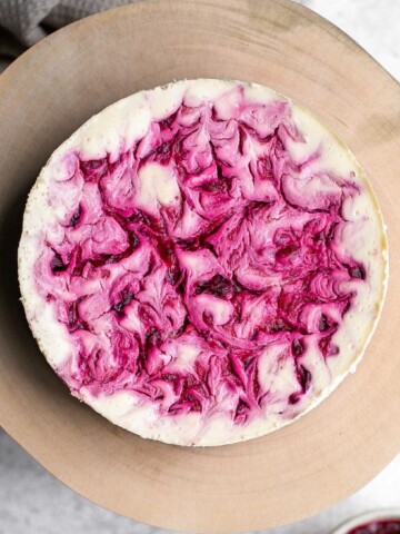 Cranberry sauce swirl cheesecake is creamy, smooth, and indulgent. With a gorgeous red swirl on top, it's the perfect holiday dessert for your next party. | aheadofthyme.com