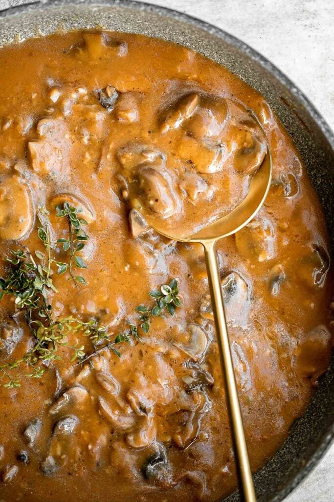 Vegetarian mushroom gravy is creamy, savory and thick, easy to make, loaded with flavor, and pairs well with everything! Make it vegan and dairy-free too. | aheadofthyme.com