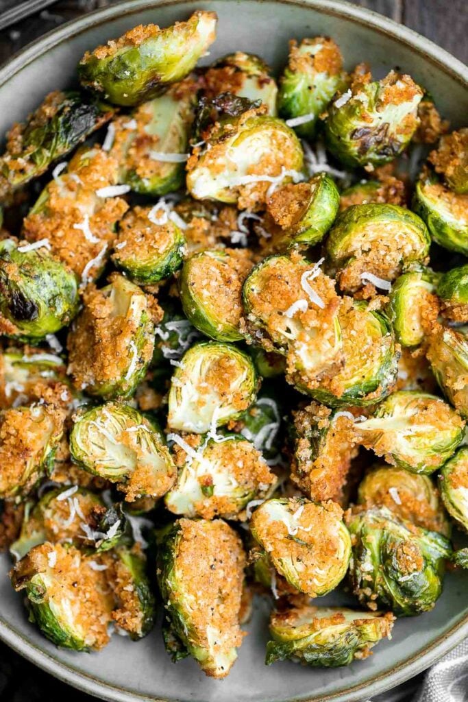 Parmesan crusted Brussels sprouts are a quick, easy, delicious side dish that's perfectly crispy outside and soft and tender inside. Ready in 30 minutes. | aheadofthyme.com