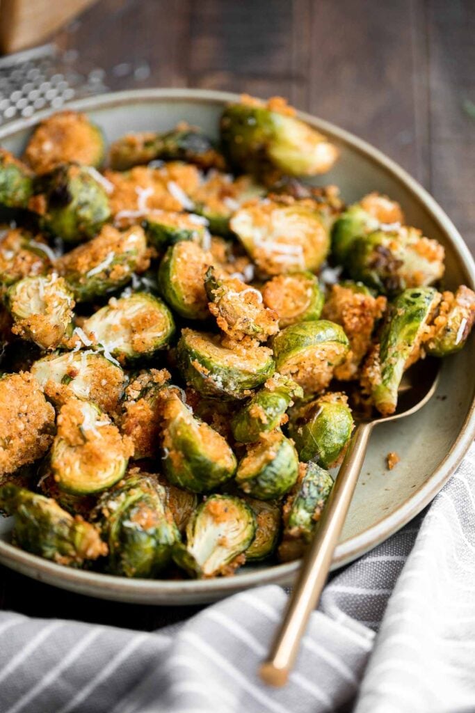 Parmesan crusted Brussels sprouts are a quick, easy, delicious side dish that's perfectly crispy outside and soft and tender inside. Ready in 30 minutes. | aheadofthyme.com