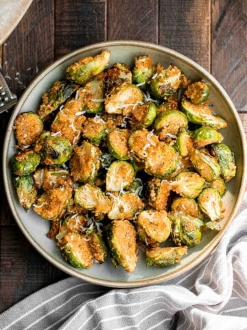 Parmesan crusted Brussels sprouts are a quick, easy, delicious side dish that's perfectly crispy outside and soft and tender inside. Ready in 30 minutes. | aheadofthyme.com