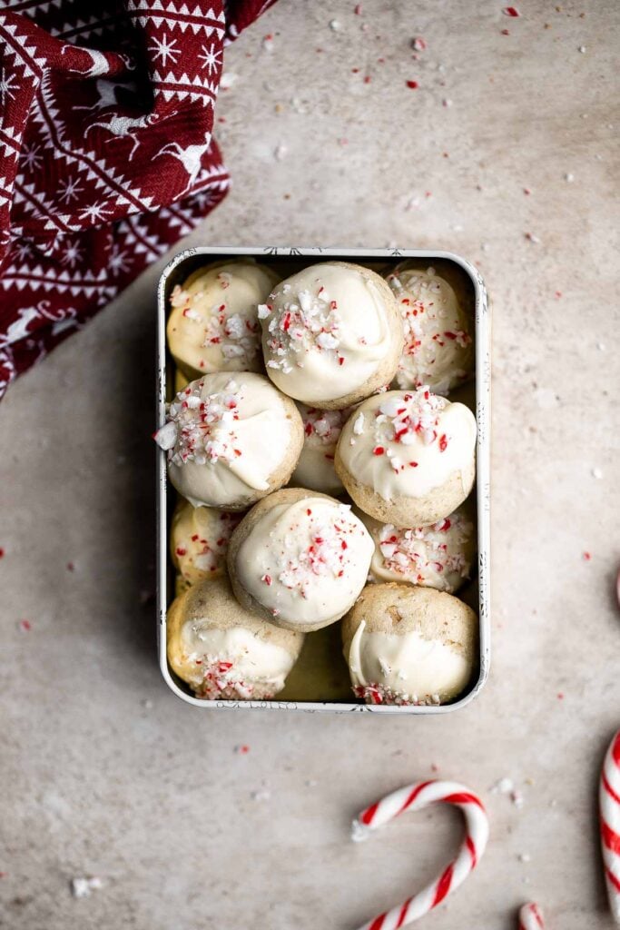 Peppermint snowball cookies are a buttery, nutty, shortbread holiday cookie that is topped with white chocolate and crushed candy canes. So festive! | aheadofthyme.com