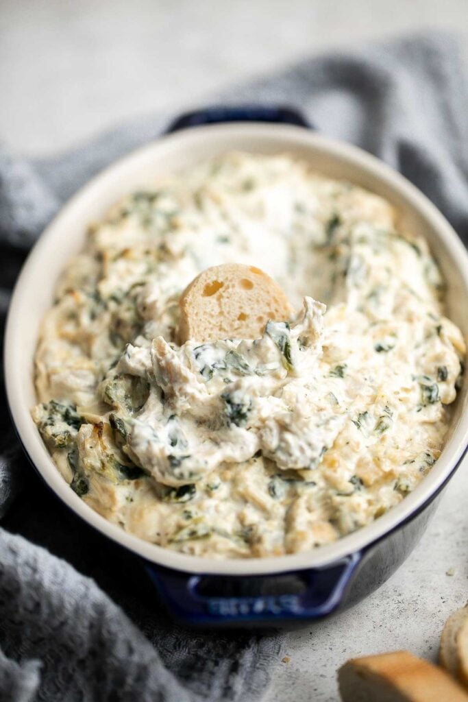 This baked spinach artichoke dip is quick, easy, creamy, flavorful, and delicious. This warm dip is baked in the oven and served with bread or crackers. | aheadofthyme.com