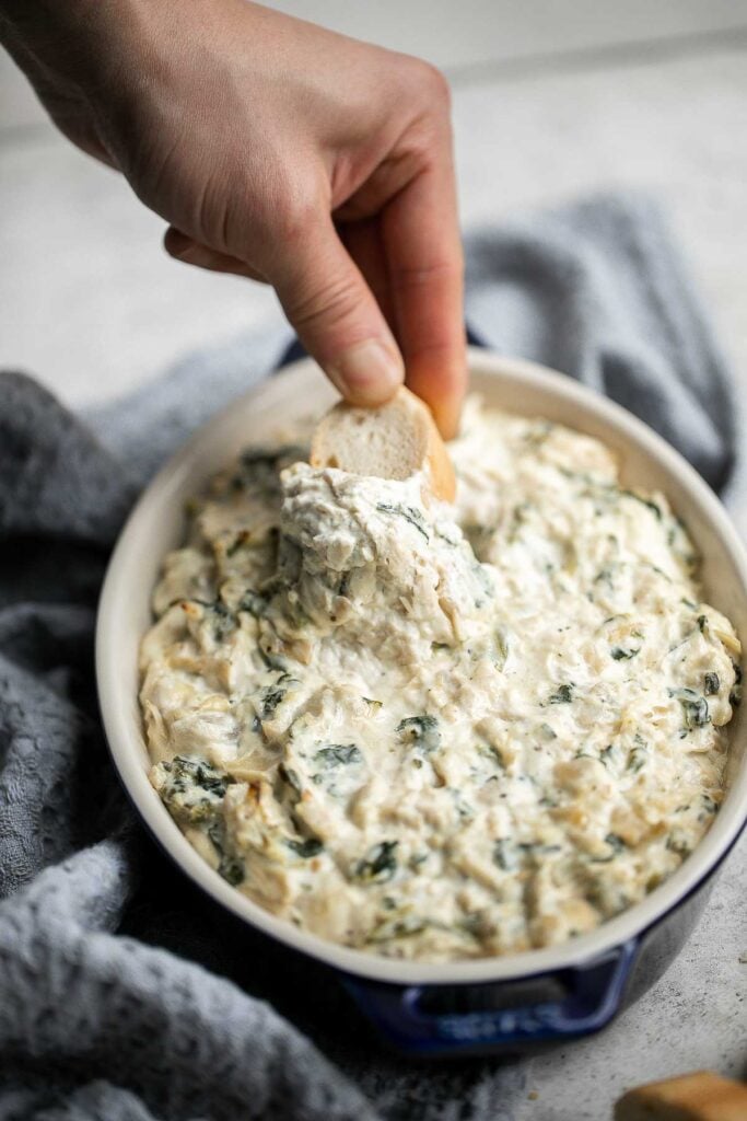 This baked spinach artichoke dip is quick, easy, creamy, flavorful, and delicious. This warm dip is baked in the oven and served with bread or crackers. | aheadofthyme.com