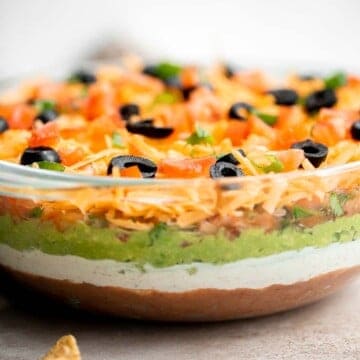 This easy and delicious 7 layer dip is the perfect dip to serve at your next party, made with layers of beans, guacamole, salsa, cheese, and more. | aheadofthyme.com