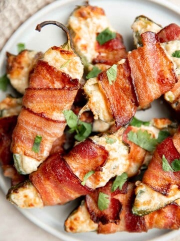 Bacon wrapped jalapeño poppers are crispy on the outside, creamy and cheesy inside, spicy, and wrapped in bacon. Easy to make in the air fryer or oven. | aheadofthyme.com
