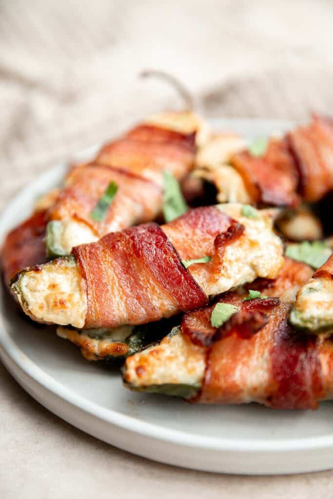 Bacon wrapped jalapeño poppers are crispy on the outside, creamy and cheesy inside, spicy, and wrapped in bacon. Easy to make in the air fryer or oven. | aheadofthyme.com