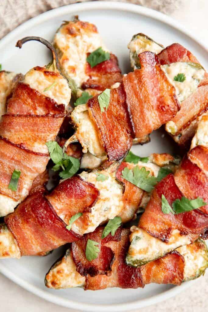 Bacon wrapped jalapeño poppers are crispy on the outside, creamy and cheesy inside, spicy, and wrapped in bacon. Easy to make in the air fryer or oven. | aheadofthyme.com