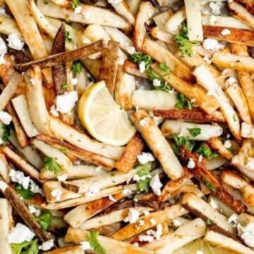 Homemade Greek fries bring a Mediterranean twist on a classic side dish, crispy fries are topped with crumbled feta cheese, fresh parsley, and lime juice. | aheadofthyme.com