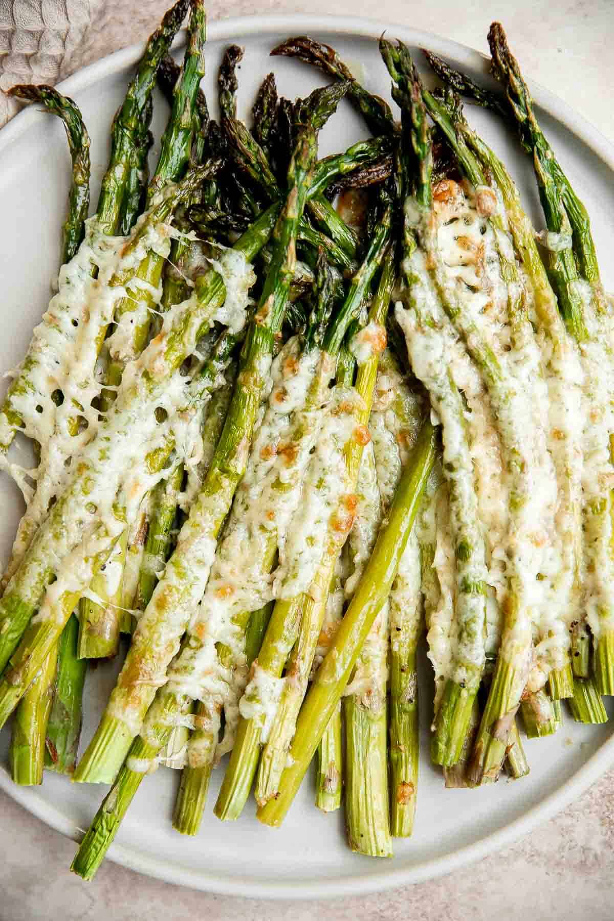 Cheesy roasted asparagus is a quick and easy side dish made with a handful of simple ingredients in 20 minutes. They’re garlicky, cheesy, and flavorful. | aheadofthyme.com