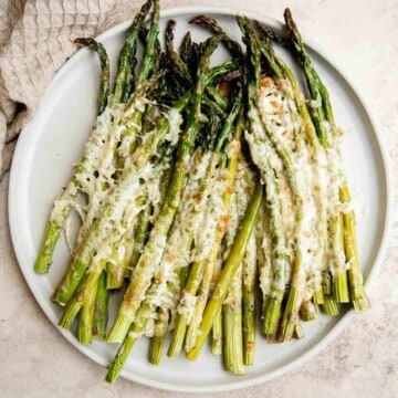 Cheesy roasted asparagus is a quick and easy side dish made with a handful of simple ingredients in 20 minutes. They’re garlicky, cheesy, and flavorful. | aheadofthyme.com