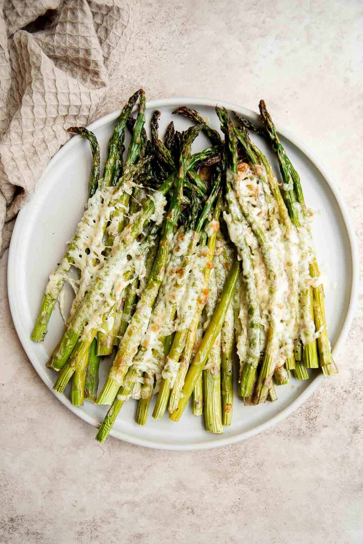 Cheesy roasted asparagus is a quick and easy side dish made with a handful of simple ingredients in 20 minutes. They’re garlicky, cheesy, and flavorful. | aheadofthyme.com