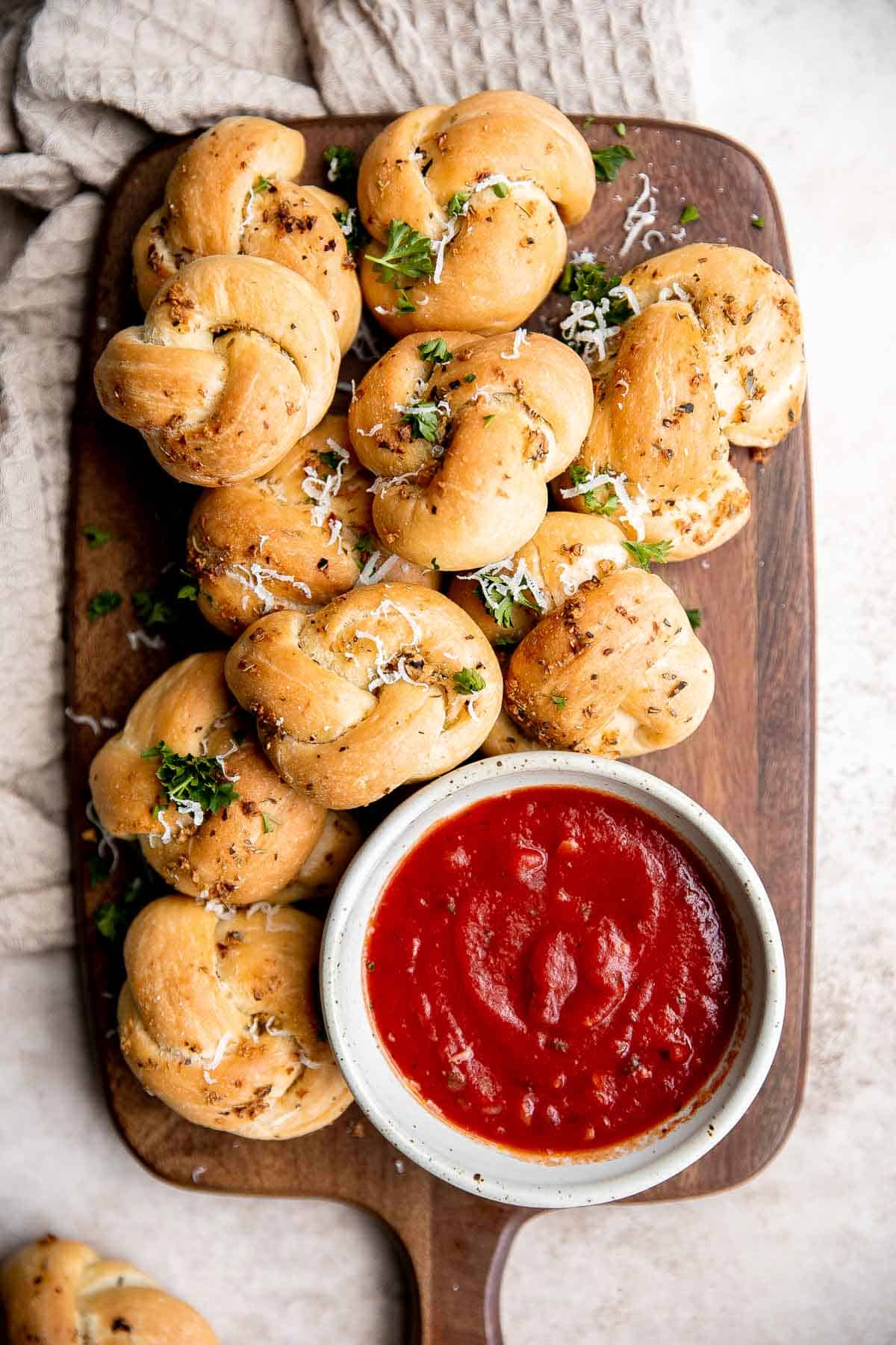 Garlic knots are fluffy on the inside, crispy on the outside, and topped with delicious savory garlic herbed butter that will have you begging for more. | aheadofthyme.com