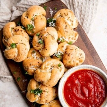 Garlic knots are fluffy on the inside, crispy on the outside, and topped with delicious savory garlic herbed butter that will have you begging for more. | aheadofthyme.com