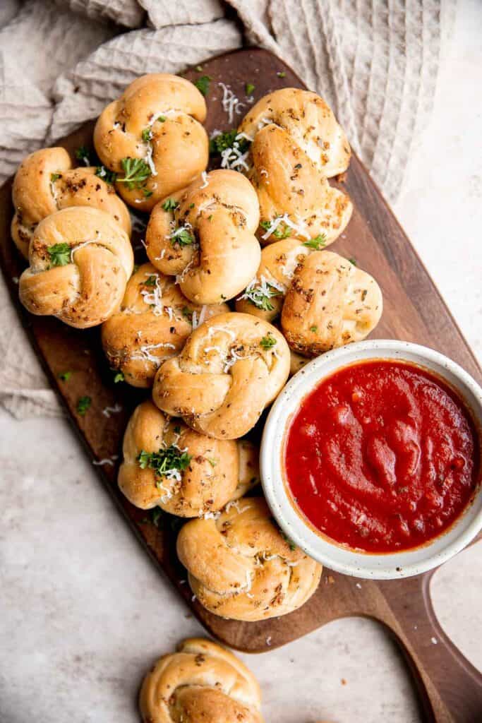 Garlic knots are fluffy on the inside, crispy on the outside, and topped with delicious savory garlic herbed butter that will have you begging for more. | aheadofthyme.com