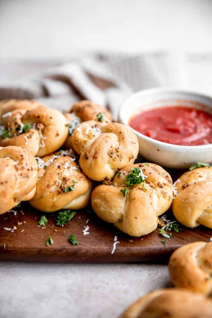 Garlic knots are fluffy on the inside, crispy on the outside, and topped with delicious savory garlic herbed butter that will have you begging for more. | aheadofthyme.com