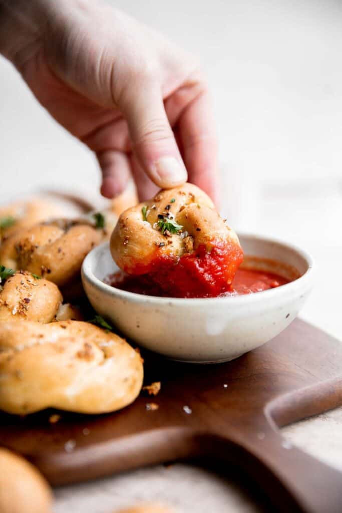 Garlic knots are fluffy on the inside, crispy on the outside, and topped with delicious savory garlic herbed butter that will have you begging for more. | aheadofthyme.com