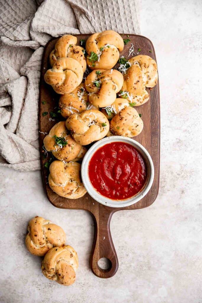 Garlic knots are fluffy on the inside, crispy on the outside, and topped with delicious savory garlic herbed butter that will have you begging for more. | aheadofthyme.com