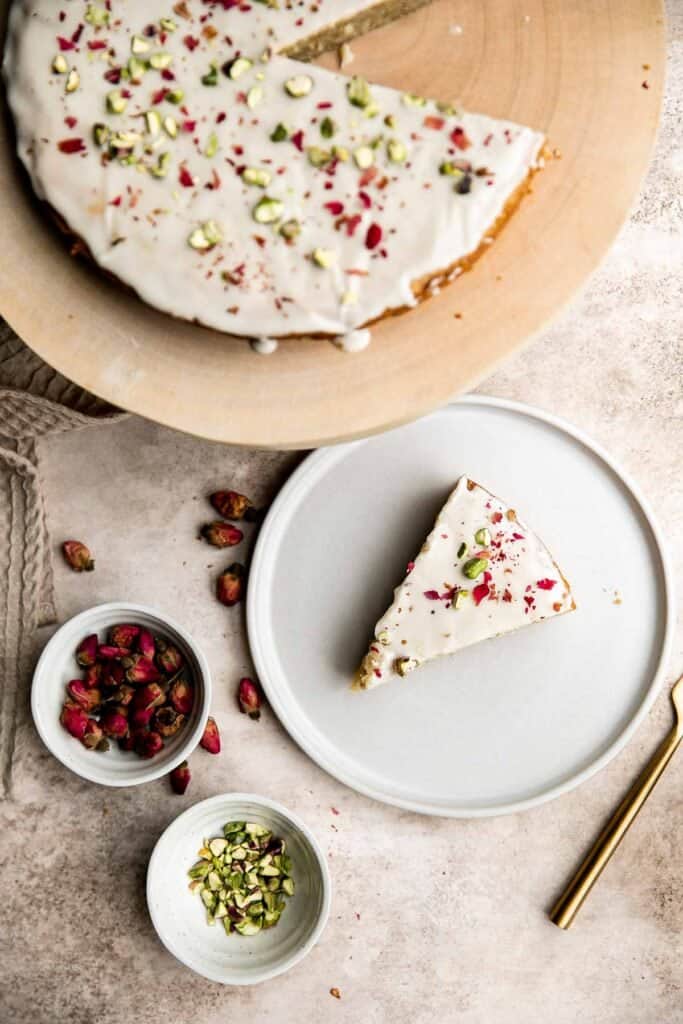 Persian Love Cake is a rich, moist, and nutty almond cake loaded with floral and citrus flavors, topped with a lemon glaze, pistachios, and rose petals. | aheadofthyme.com