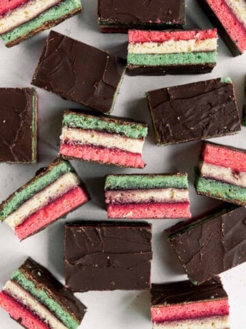 Italian rainbow cookies are delicious, colorful, fluffy, and gorgeous, made with three cake layers sandwiched in between jam and covered in chocolate. | aheadofthyme.com