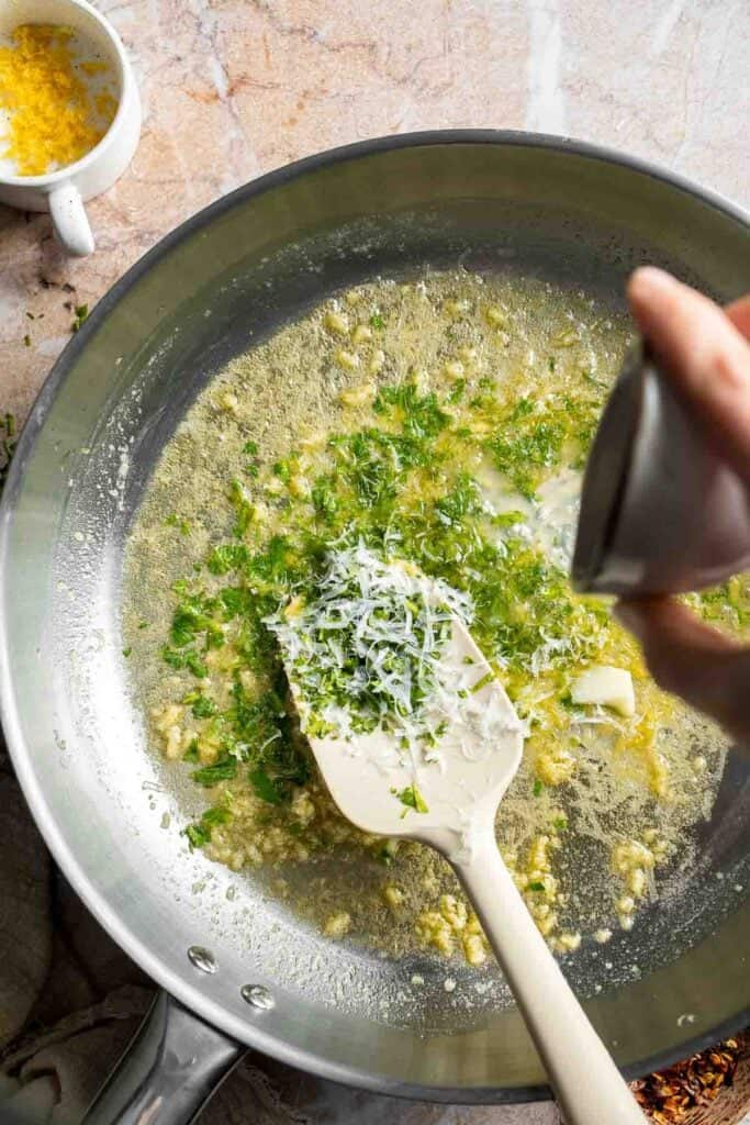 Adding fresh lemon juice to the butter sauce.