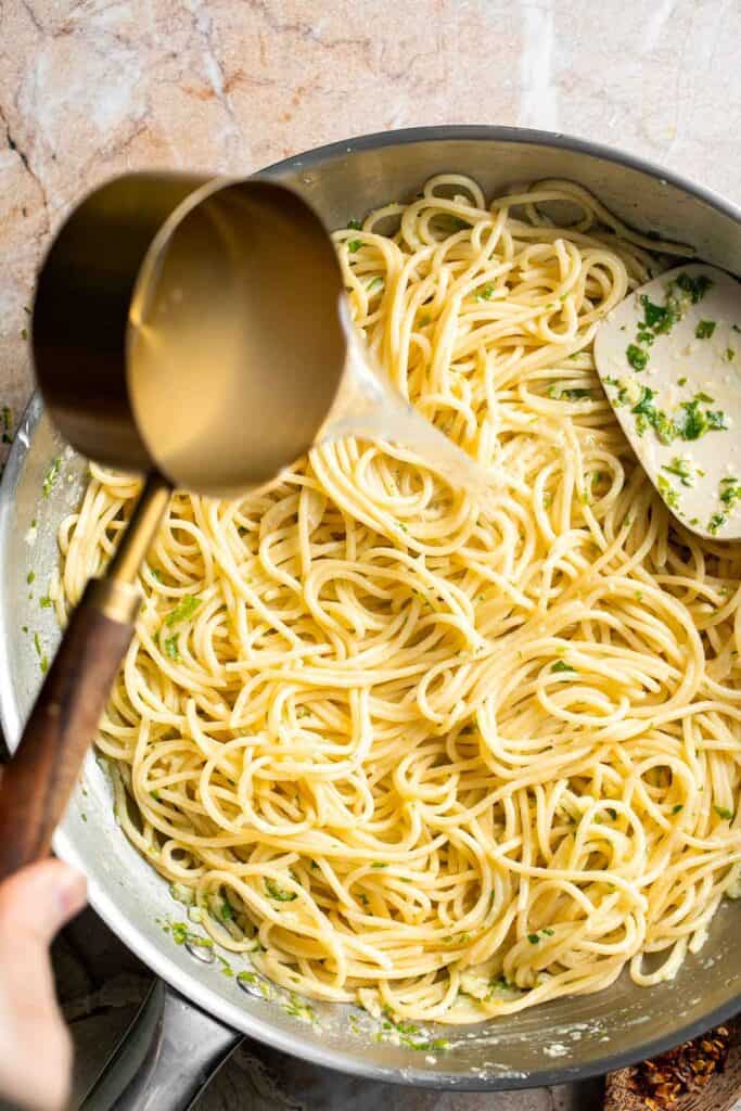 Adding reserved pasta water to create a silky lemon butter pasta sauce.