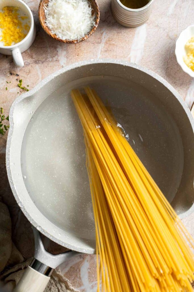 Cooking spaghetti in boiling water for lemon butter pasta.