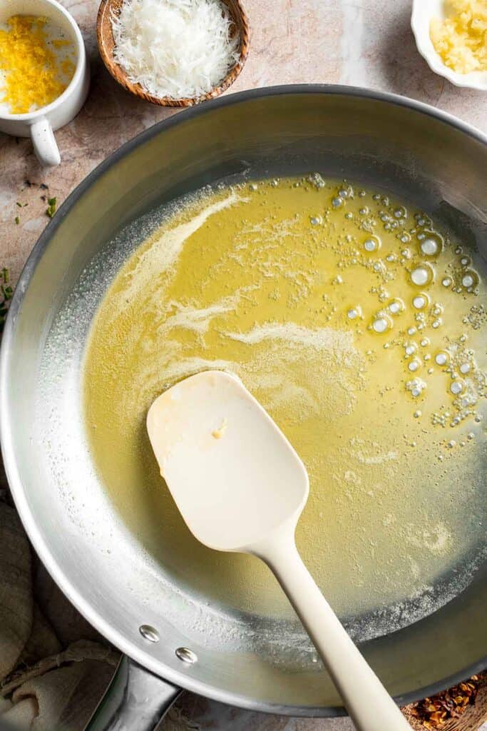 Melting butter in a skillet for lemon butter pasta.
