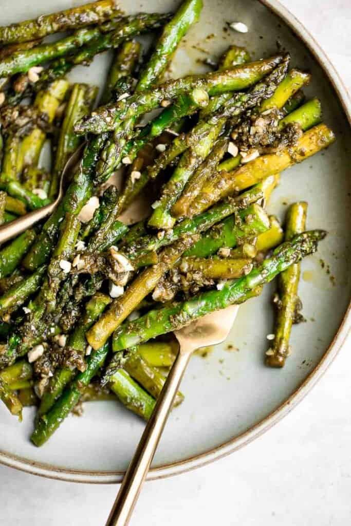 Pesto asparagus is a quick easy side dish that takes regular sautéed asparagus to the next level in just 15 minutes. It's healthy, vegan, and gluten-free. | aheadofthyme.com