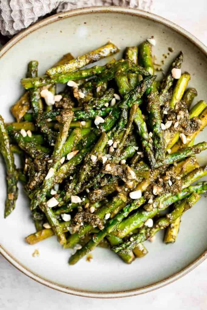 Pesto asparagus is a quick easy side dish that takes regular sautéed asparagus to the next level in just 15 minutes. It's healthy, vegan, and gluten-free. | aheadofthyme.com