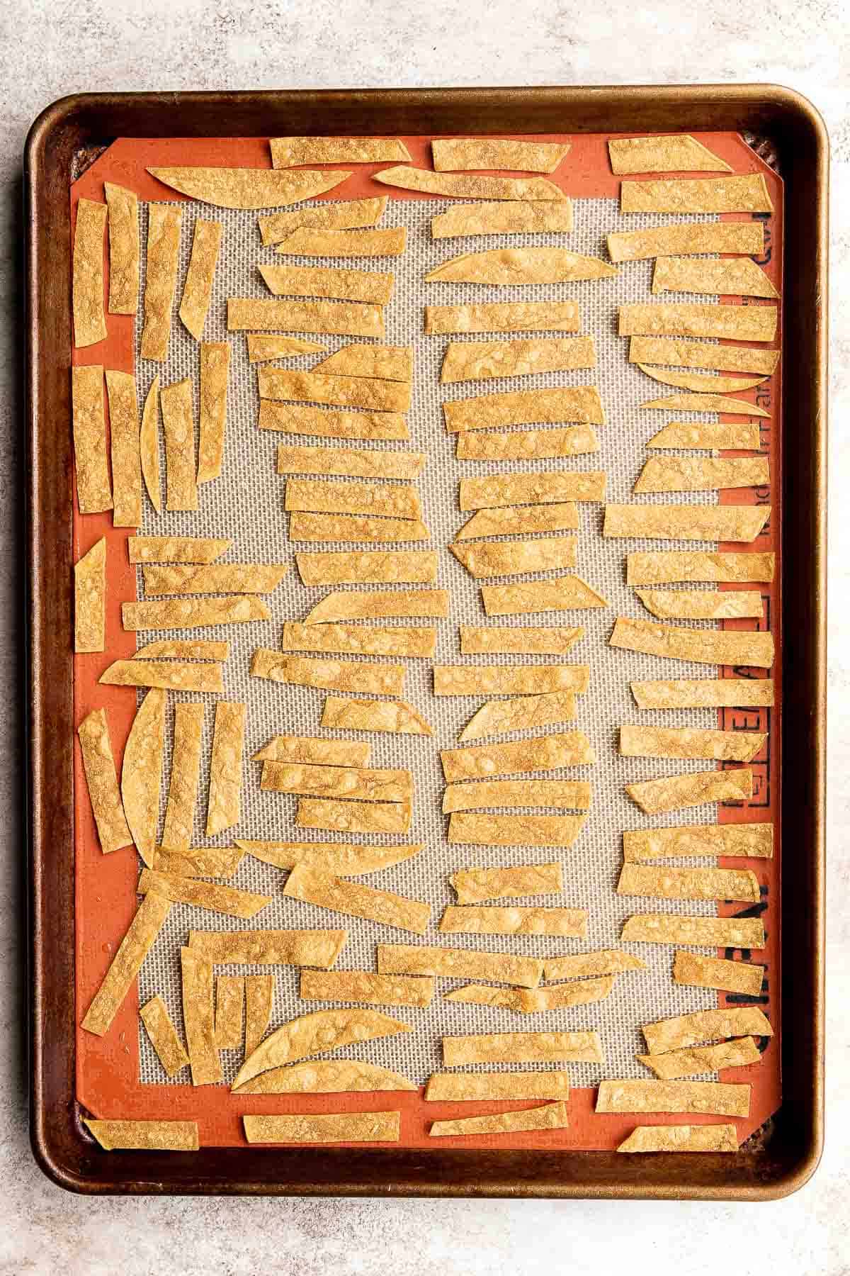 Baked tortilla strips on a large sheet pan. | aheadofthyme.com