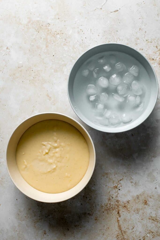 A bowl of warm homemade vanilla pudding next to a water bath for chilling. | aheadofthyme.com