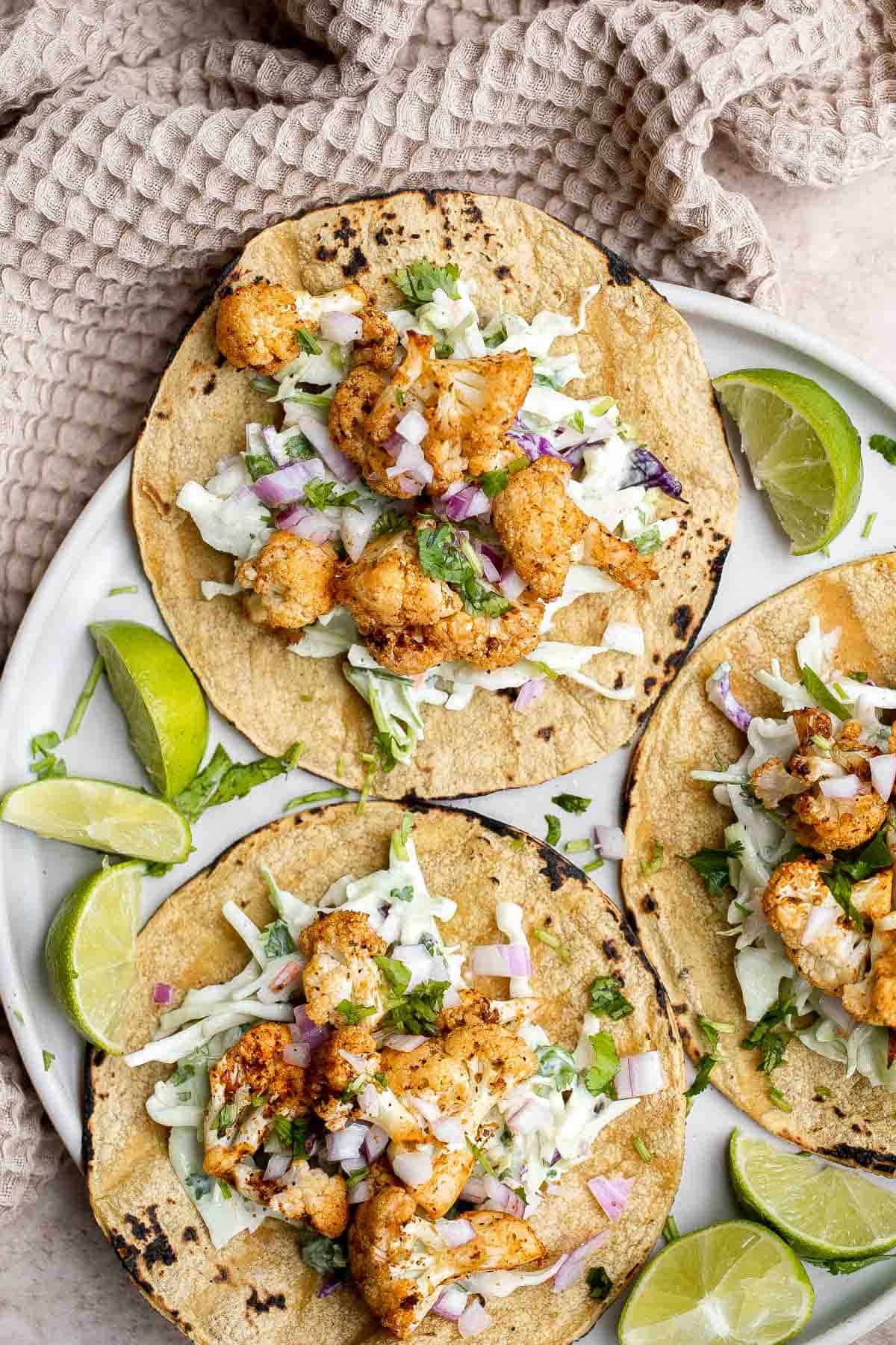 Vegetarian cauliflower tacos are loaded with air-fried or baked cauliflower, a delicious seasoning blend, and creamy lime cilantro slaw inside a tortilla. | aheadofthyme.com