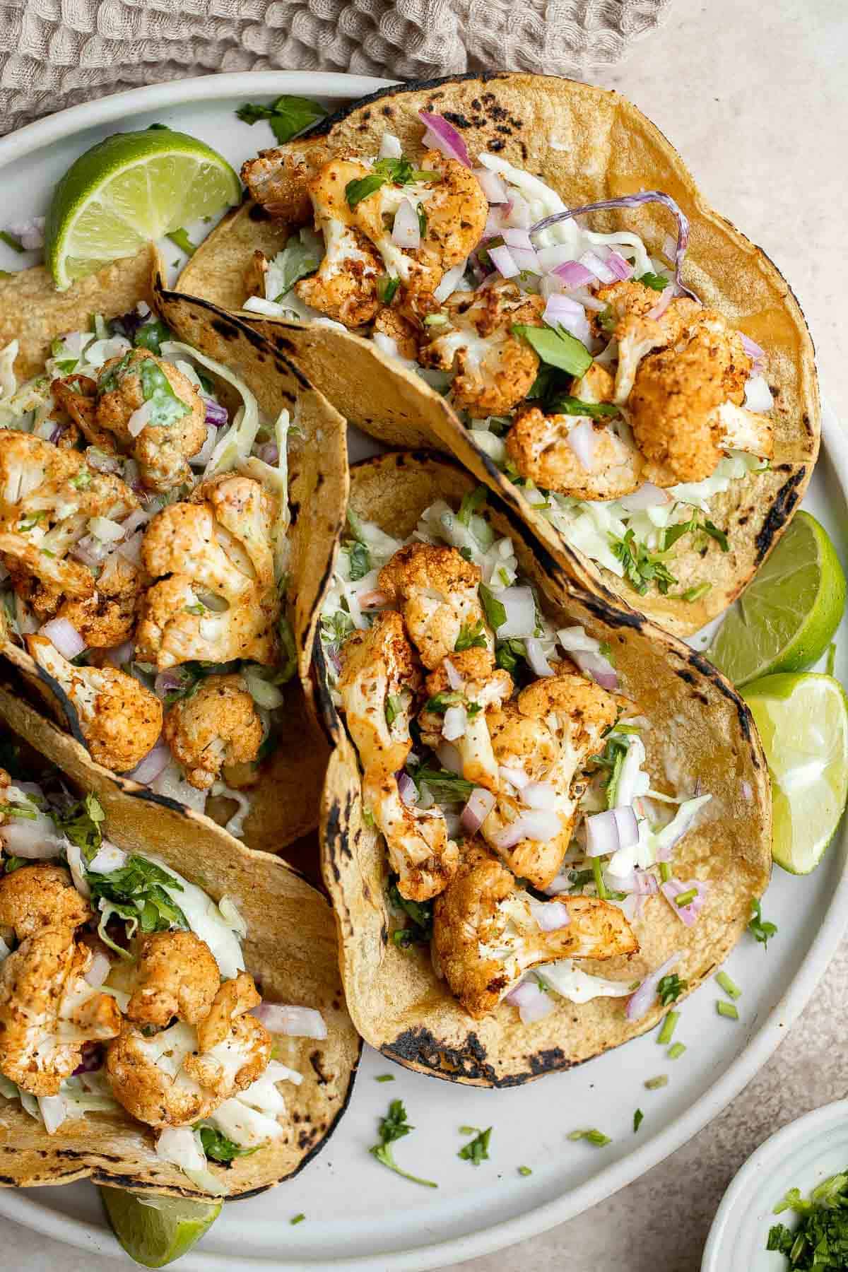 Vegetarian cauliflower tacos are loaded with air-fried or baked cauliflower, a delicious seasoning blend, and creamy lime cilantro slaw inside a tortilla. | aheadofthyme.com