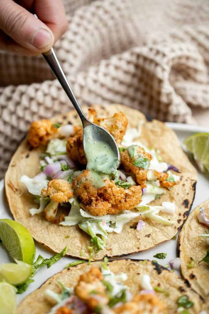 Vegetarian cauliflower tacos are loaded with air-fried or baked cauliflower, a delicious seasoning blend, and creamy lime cilantro slaw inside a tortilla. | aheadofthyme.com