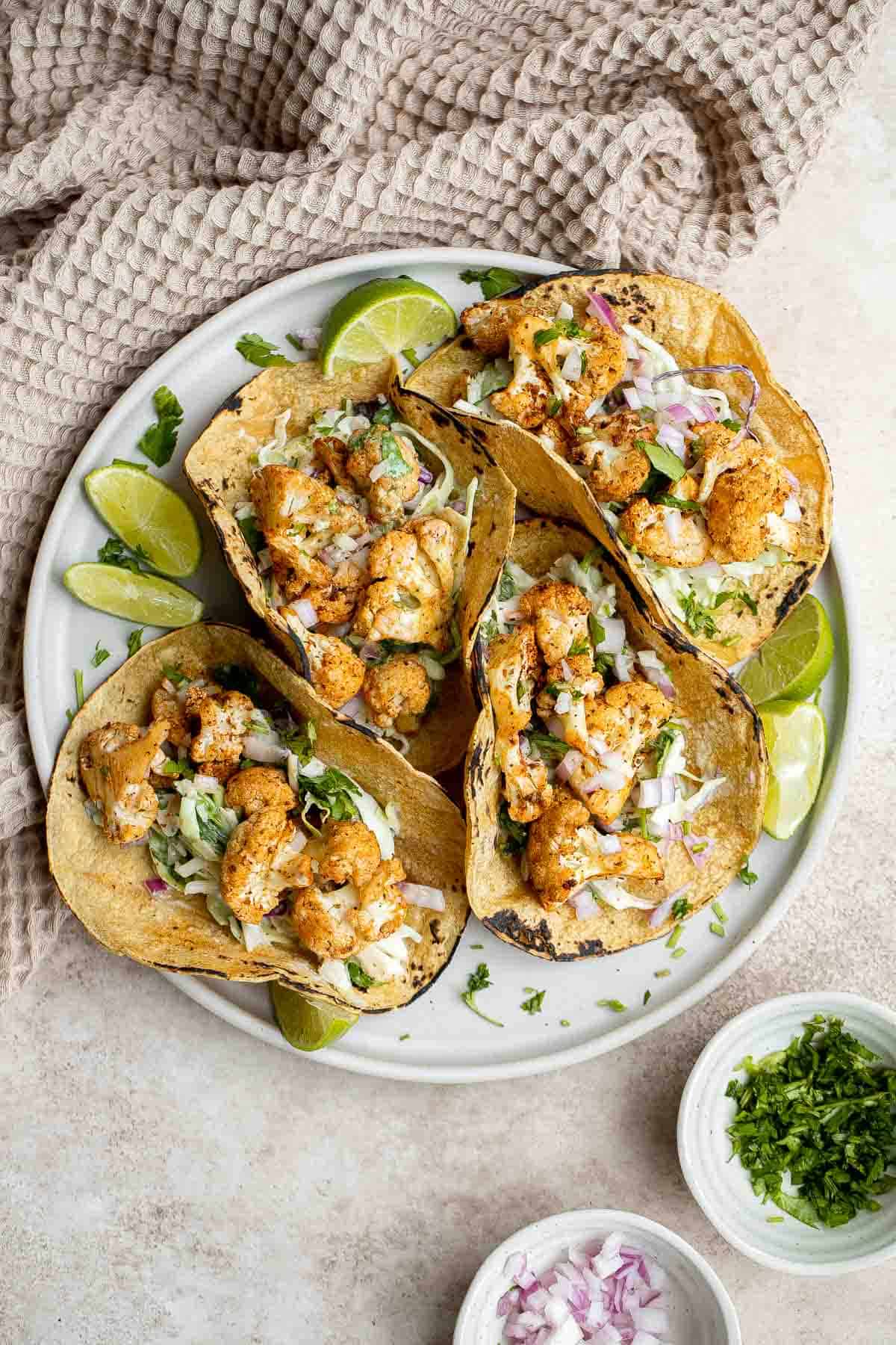 Vegetarian cauliflower tacos are loaded with air-fried or baked cauliflower, a delicious seasoning blend, and creamy lime cilantro slaw inside a tortilla. | aheadofthyme.com