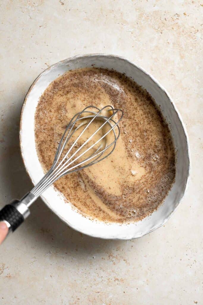 Eggs, milk, cinnamon, and salt mixed together in a shallow bowl. | aheadofthyme.com