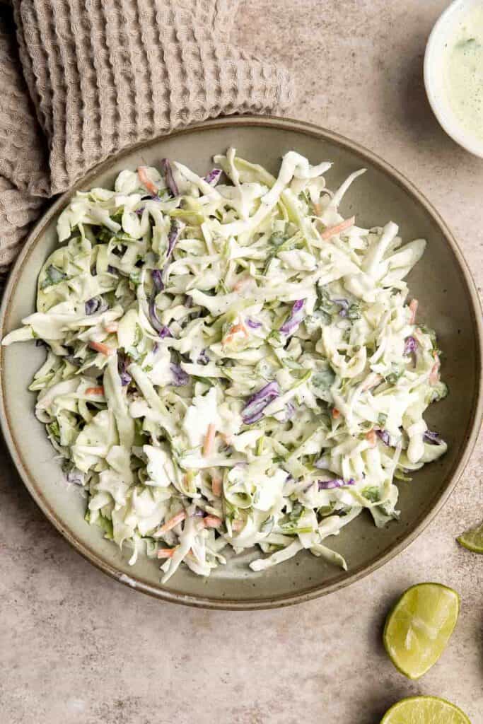 Cilantro lime slaw is fresh, light, crunchy, and zesty. Ready in 5 minutes, it’s the perfect pairing for tacos, burgers, sandwiches, and barbecued meats. | aheadofthyme.com