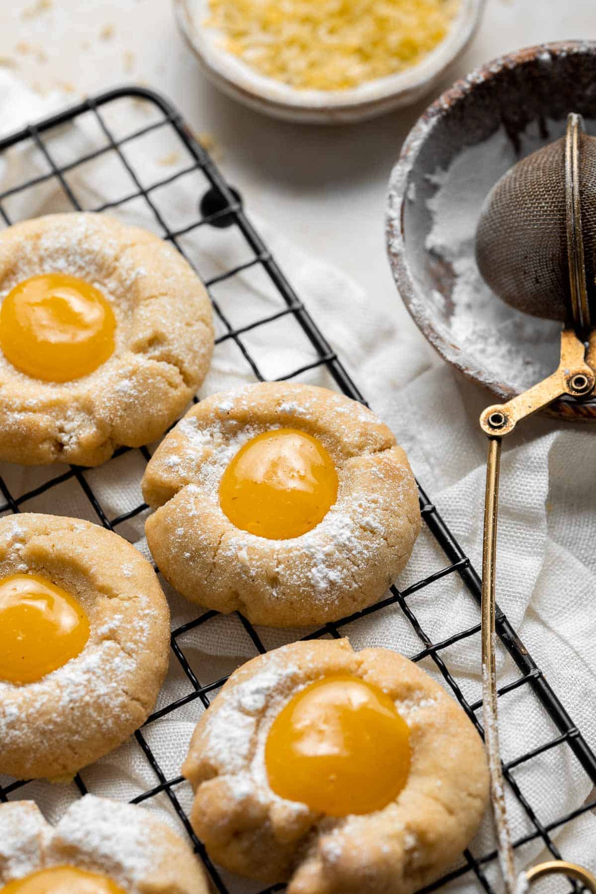 Sweet and sour Lemon Curd Cookies are made of buttery shortbread thumbprint cookies dusted with powdered sugar, and filled with sweet and tangy lemon curd. | aheadofthyme.com