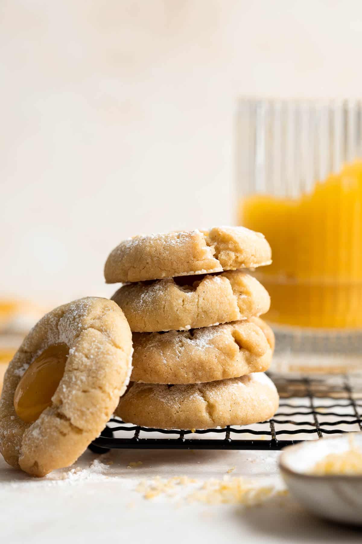 Sweet and sour Lemon Curd Cookies are made of buttery shortbread thumbprint cookies dusted with powdered sugar, and filled with sweet and tangy lemon curd. | aheadofthyme.com